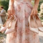 Nő színes cipőket tart a kezében egy esküvői környezetben.