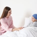 Édesanya beszélget a gyermekkori leukémiával küzdő gyermekével a kórházban.