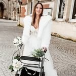 Menyasszony esküvői ruhában, járókerettel és virágcsokorral.