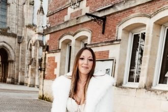 Menyasszony esküvői ruhában, járókerettel és virágcsokorral.